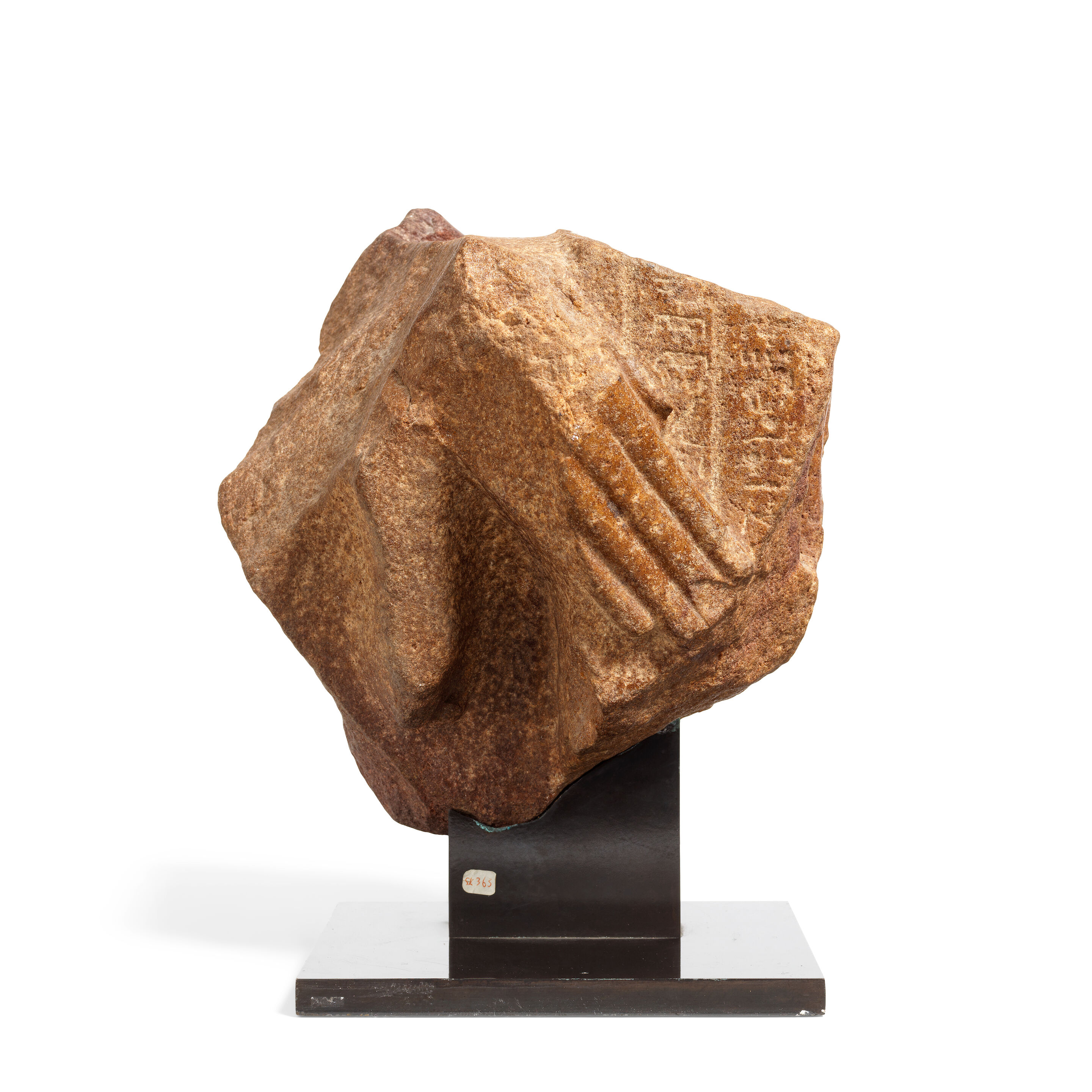 An Egyptian red quartzite fragment from a naophorous statue