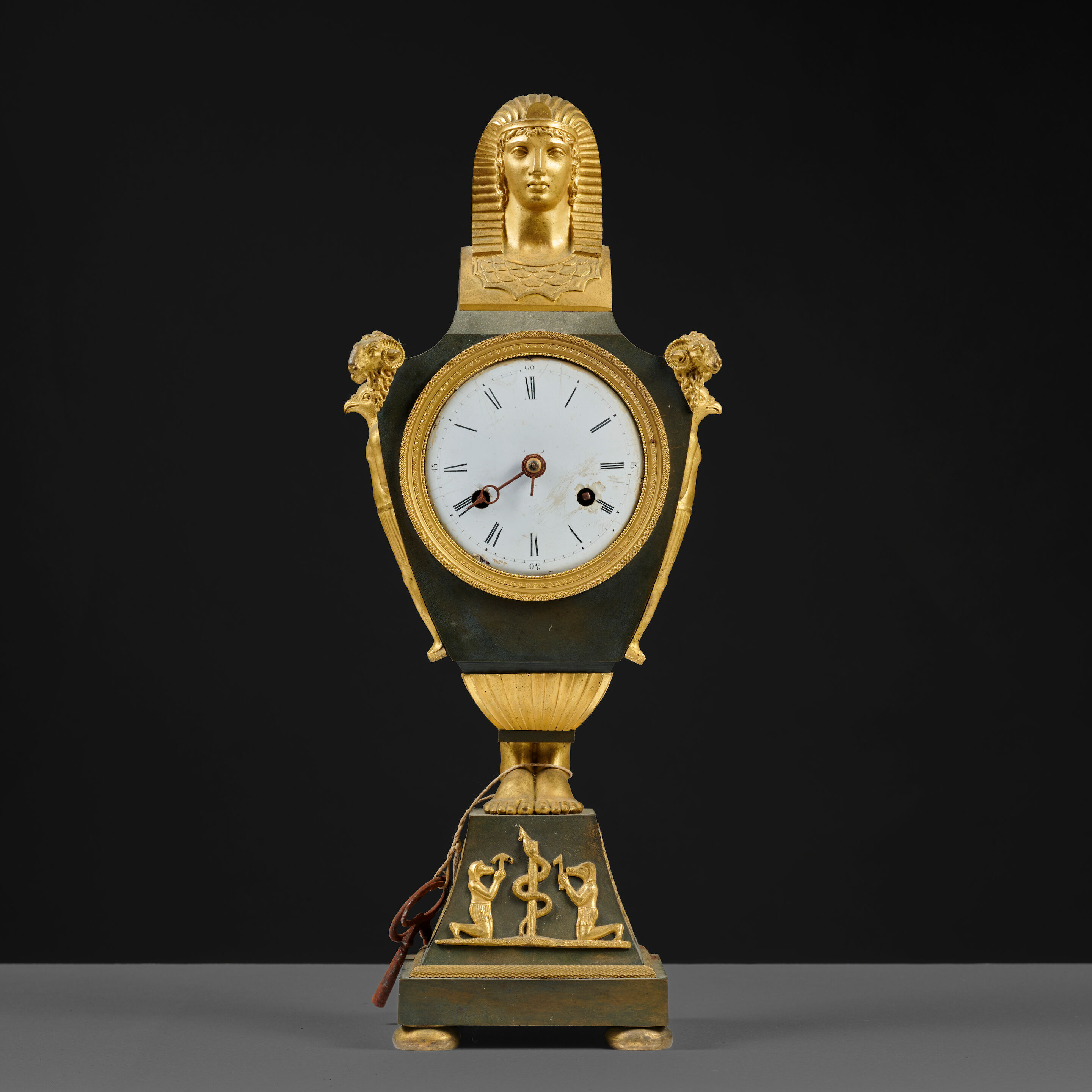 Pendule en forme d'urne en bronze doré et à patine brune d'époque Empire An urn-shaped clock in brown-patinated and gilt-bronze, first half of the 19th century