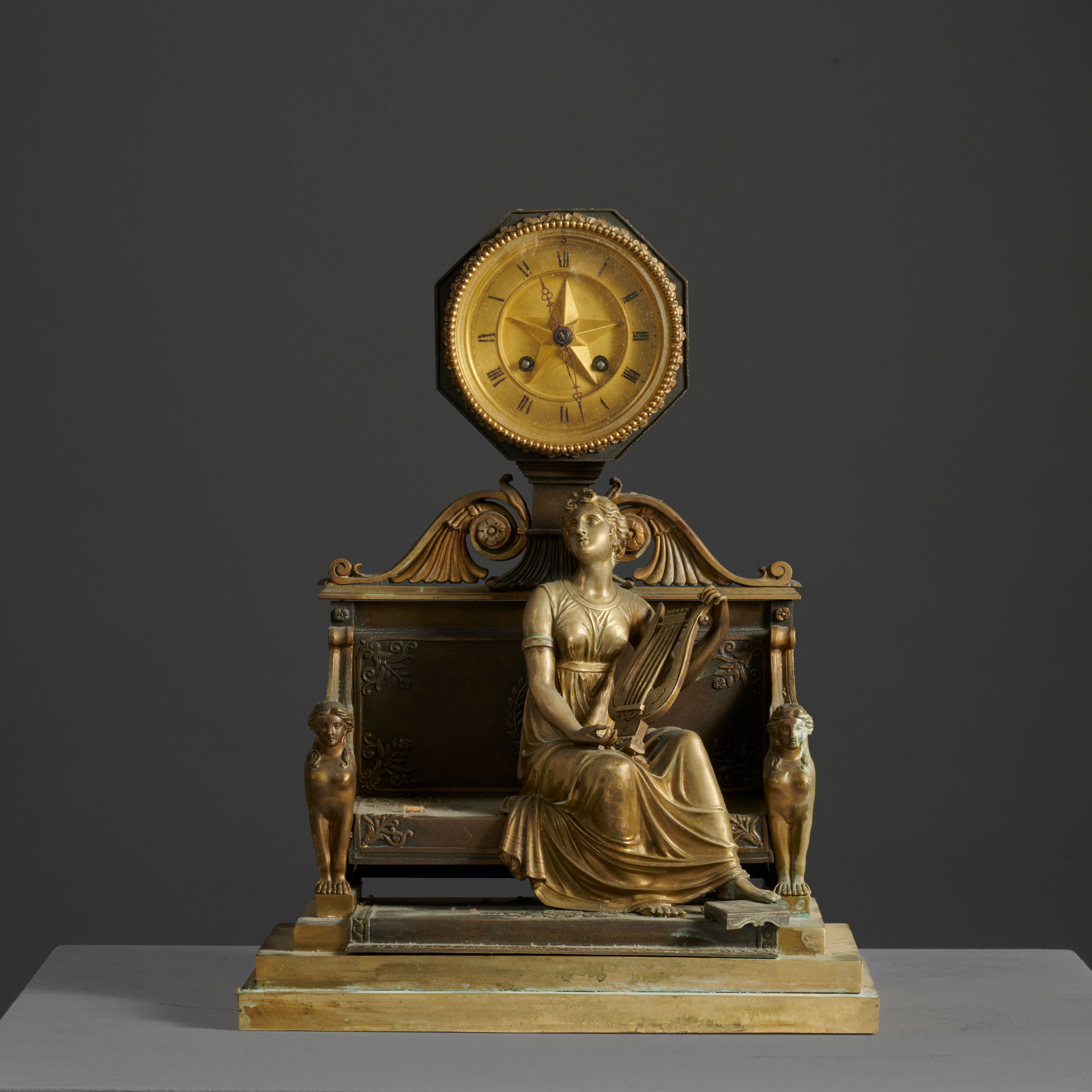 Pendule figurant Terpsychore en bronze doré et patiné de style Empire An Empire style clock depicting Terpsichore in gilt and patinated bronze