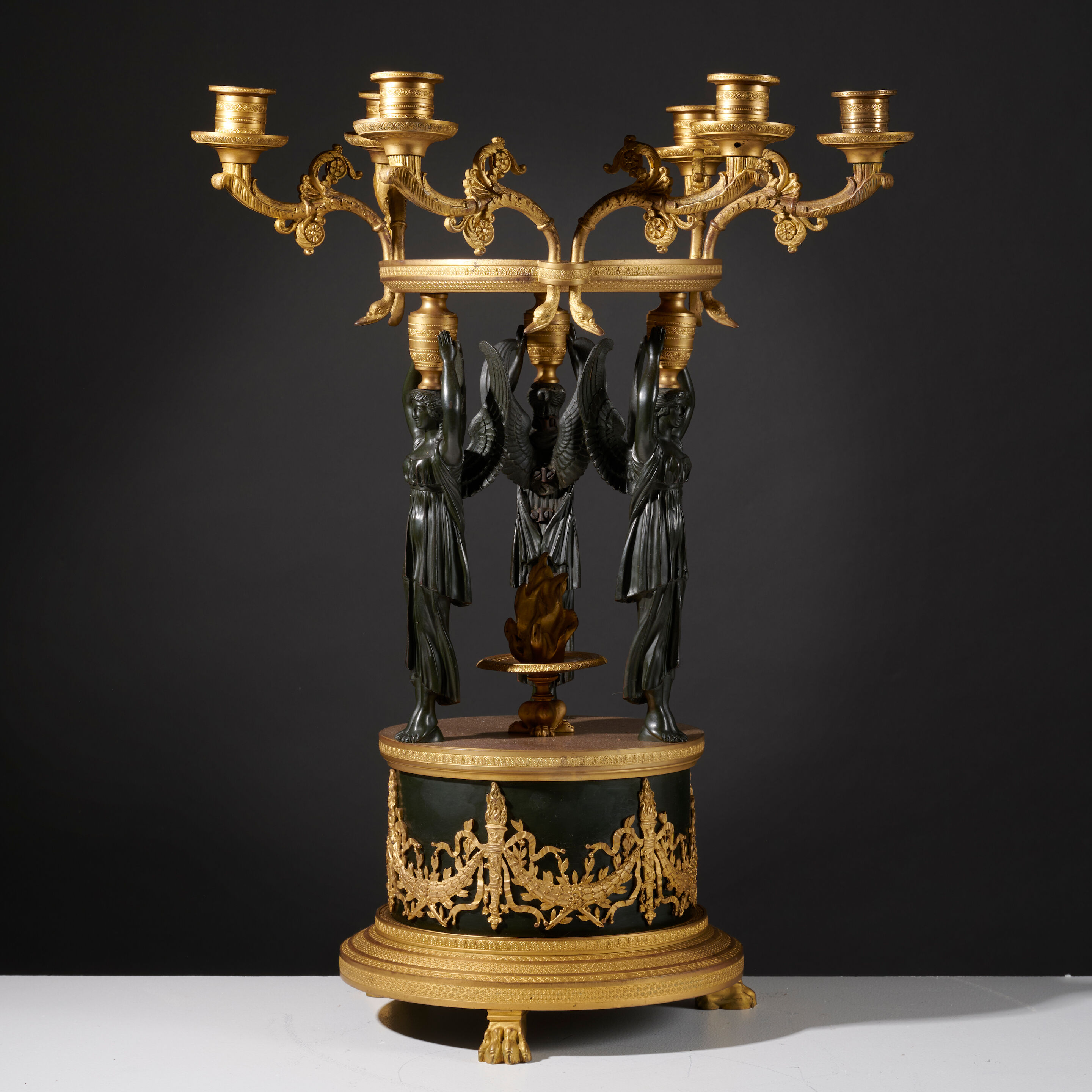 Grand centre de table en bronze doré et patiné noir présentant un cercle entouré de bras de lumières de style Empire A large Empire style centerpiece featuring a circle surrounded by candle-arms light