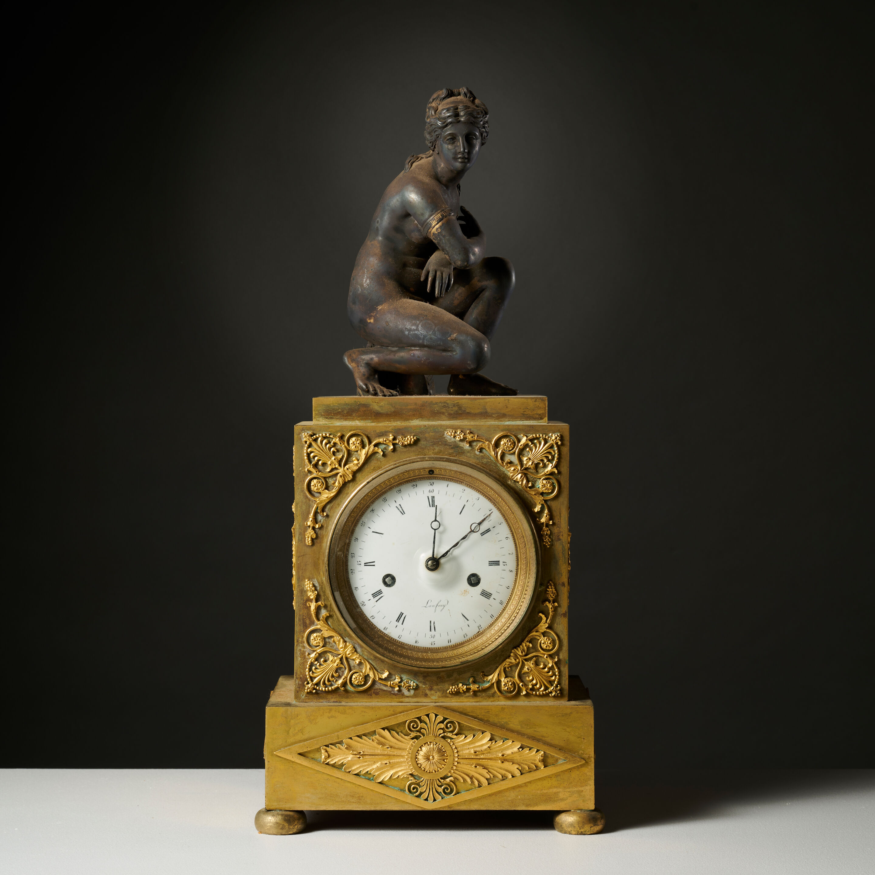 Pendule borne en bronze doré et Aphrodite accroupie en bronze patiné d'époque Restauration A gilt-bronze mantel clock with a crouching Aphrodite in patinated bronze, first half of the 19th century