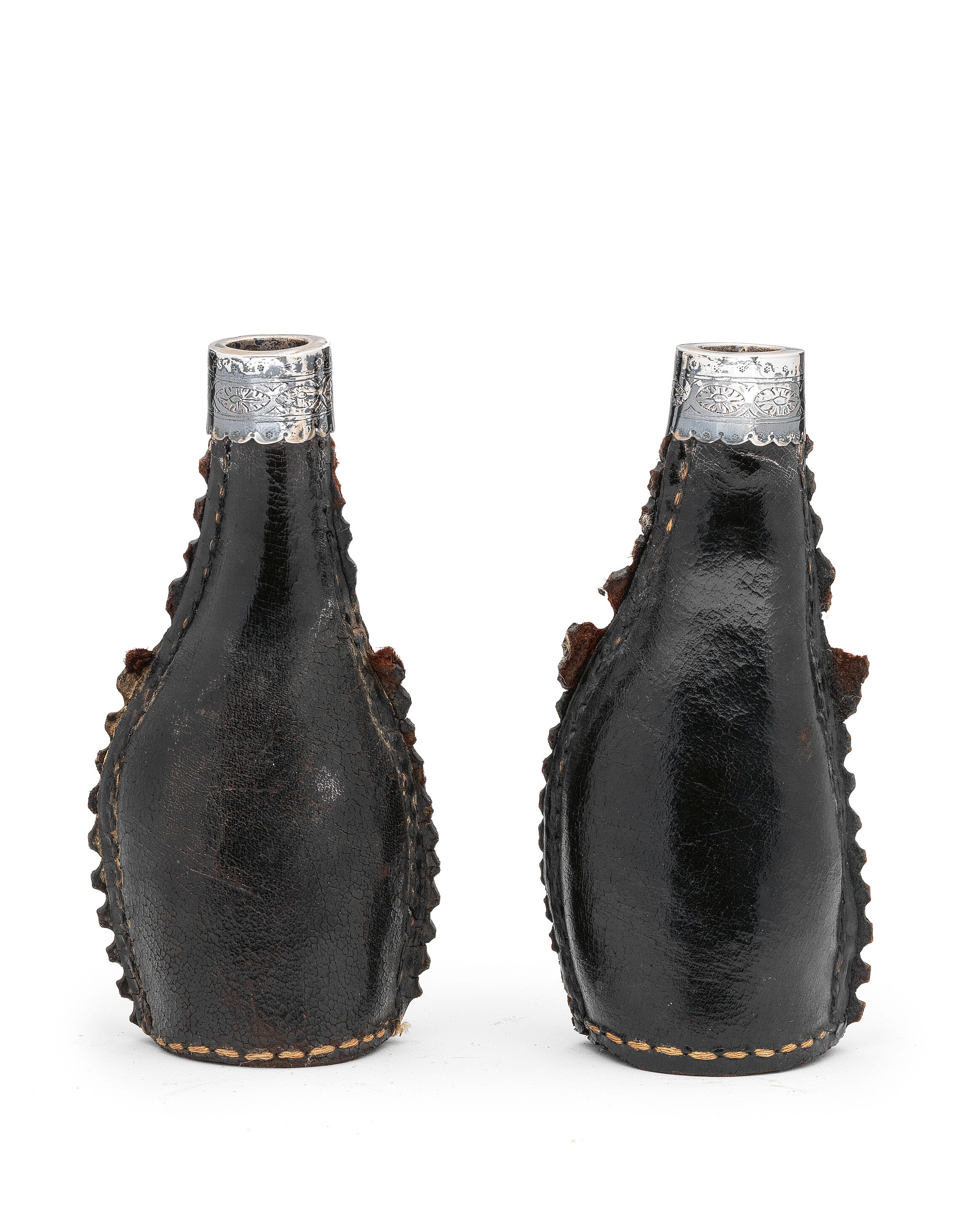 A pair of late 17th century white metal mounted leather flasks English
