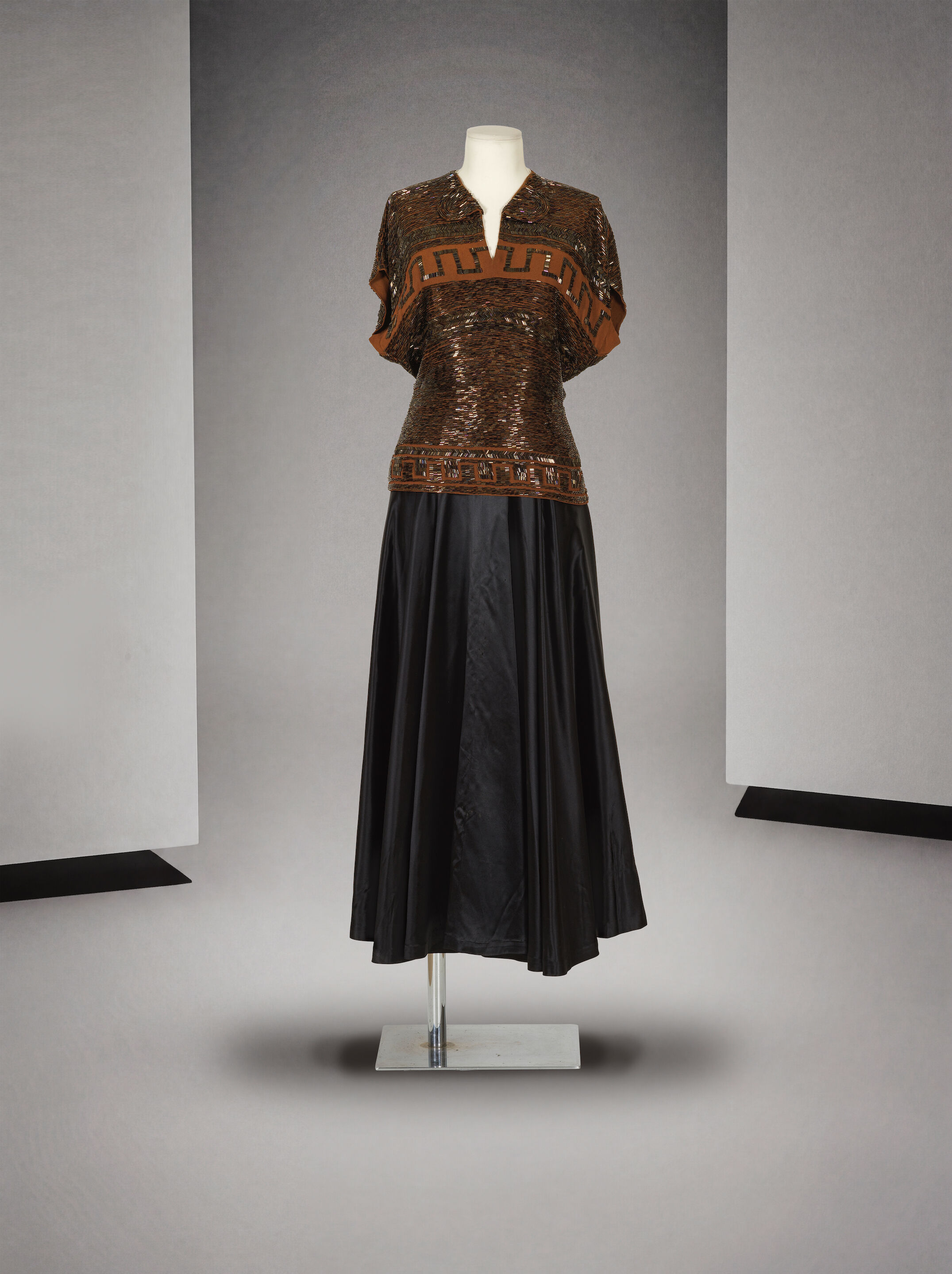 Jean Dessès attribué à, collection Haute Couture, circa 1947. Casaque en crêpe marron rebrodé. Attributed to Jean Dessès, Haute Couture collection, circa 1947. Brown crepe tunic with embroidered detailing.