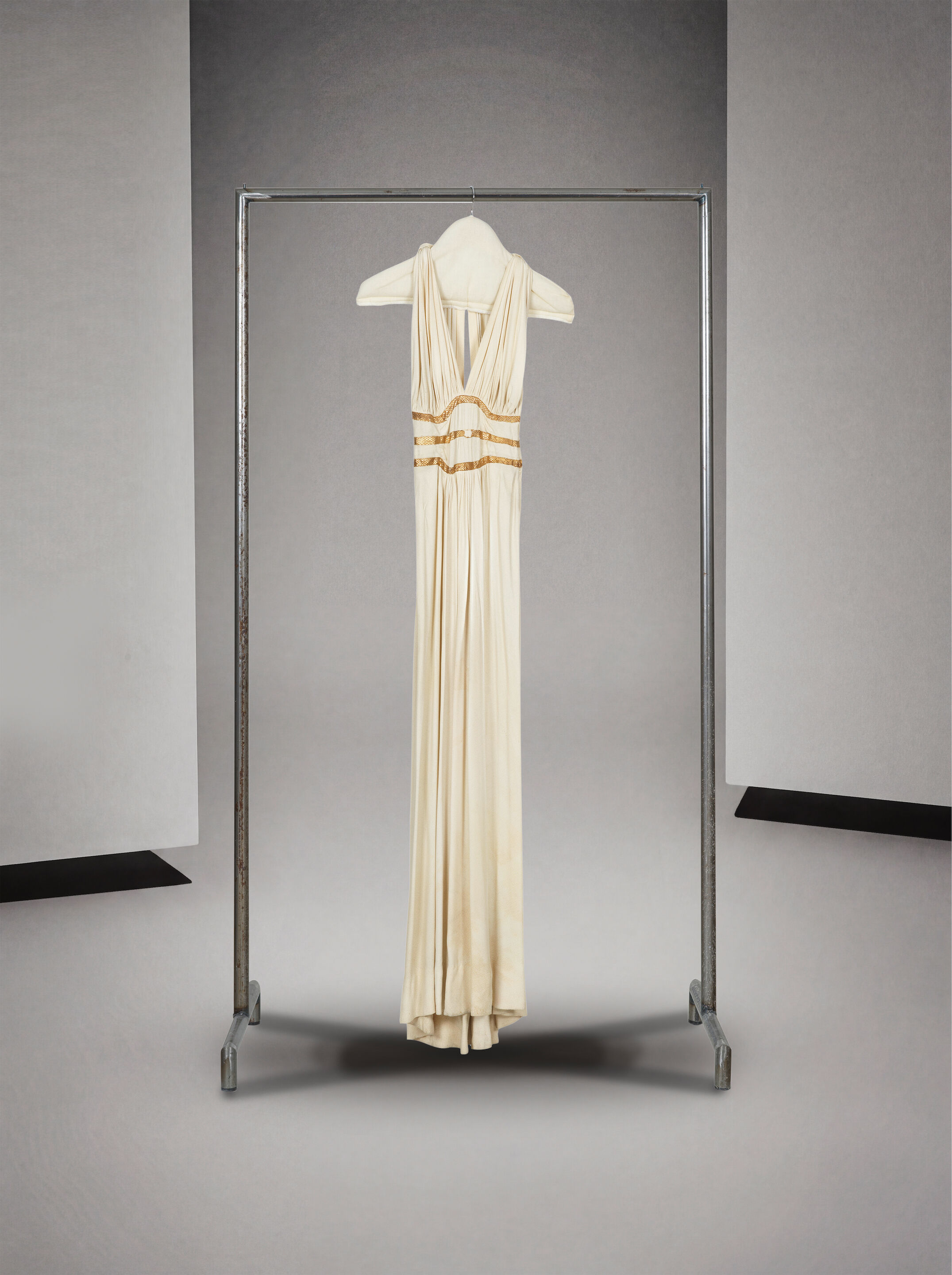 Anonyme, circa 1935. Robe du soir en crêpe ivoire et lézard or. Anonymous, circa 1935. Evening gown in ivory crepe and gold lizard skin.