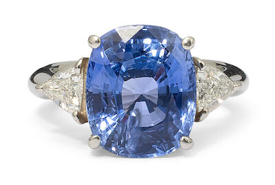 A sapphire and diamond ring set with a sapphire flanked by two diamonds, mounted in platinum. Size 52.