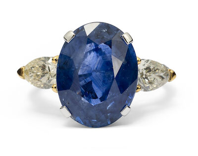 A sapphire ring set with an oval-cut Ceylon sapphire and two diamonds, mounted in 18k white gold. Size 55.